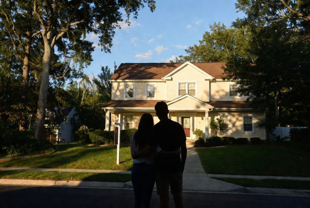 Couple standing in front of their new home in Southern Maryland